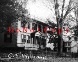 Black and White Photo of Old style house with fence around it